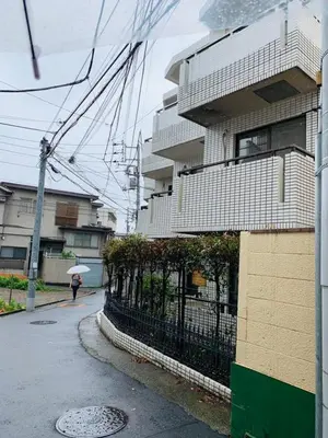 a person walking down a street with an umbrella at Okubo abia house-SJ0155 in Tokyo