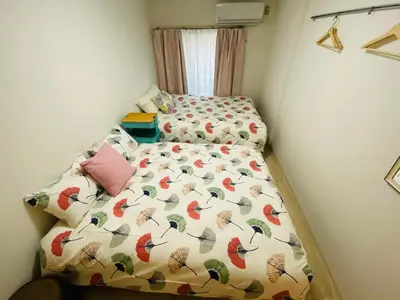 a small bedroom with a bed with a comforter at Okubo abia house-SJ0155 in Tokyo