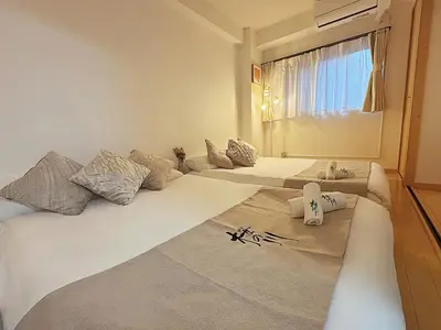 a room with three beds with pillows and a window at \u685c\u306e\u5ddd 3\u4e28\u6b65\u884c 5 \u5206 \u5de3\u9d28\u99c5 JR \u7ebf 2-8 \u4eba \u65e5\u5f0f\u516c\u5bd3\u4e285-Min Walk to Sugamo JR Line 2-8 Guests Japanese Home in Tokyo
