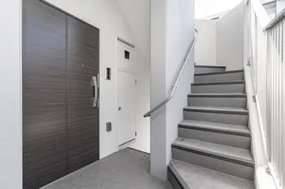 a staircase in a house with a wooden door at ZAITO Kikukawa SRS Apartment \u65b0\u7bc9\u30de\u30f3\u30b7\u30e7\u30f3 in Tokyo