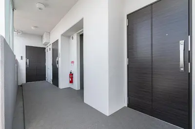 a hallway with dark wood doors and a red fire hydrant at ZAITO Kikukawa SRS Apartment \u65b0\u7bc9\u30de\u30f3\u30b7\u30e7\u30f3 in Tokyo