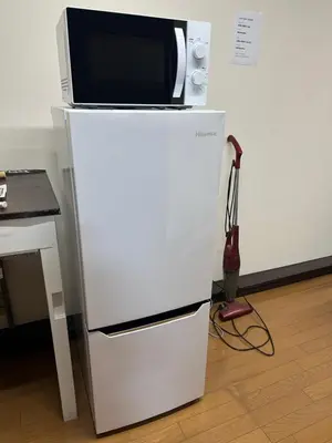 a microwave sitting on top of a refrigerator at \u6c34\u4ed9 Kamata in Tokyo
