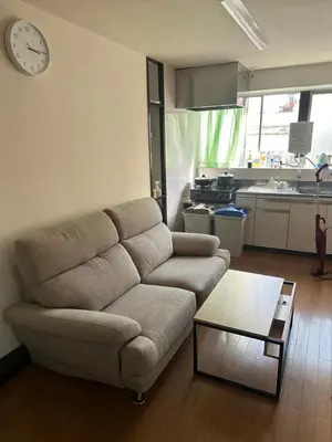 a living room with a couch and a clock on the wall at \u6c34\u4ed9 Kamata in Tokyo