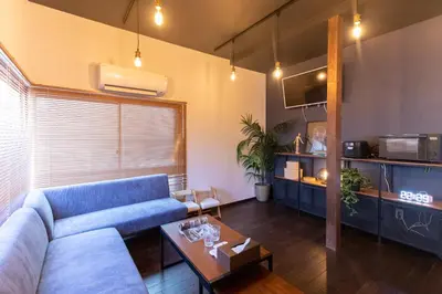a living room with a blue couch and a table at \u548c\u6c23\u4f1a\u3005\u65b0\u5927\u4e45\u4fdd Wakiaiai Shinokubo in Tokyo