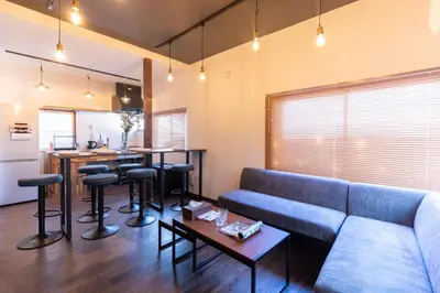 a living room with a couch and a kitchen at \u548c\u6c23\u4f1a\u3005\u65b0\u5927\u4e45\u4fdd Wakiaiai Shinokubo in Tokyo