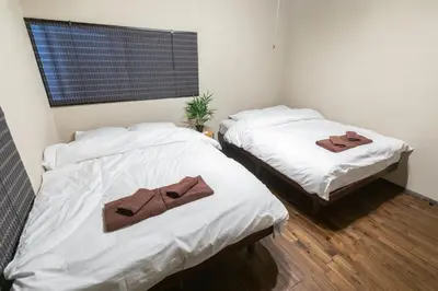 two beds with towels on them in a room at \u548c\u6c23\u4f1a\u3005\u65b0\u5927\u4e45\u4fdd Wakiaiai Shinokubo in Tokyo