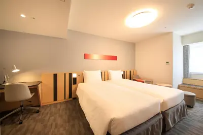 a hotel room with a large bed and a desk at Richmond Hotel Tokyo Suidobashi in Tokyo