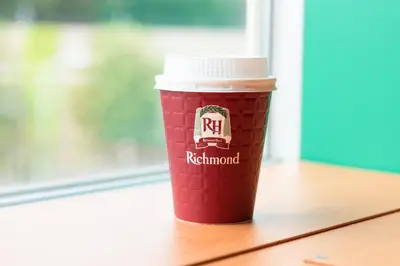 a red cup of coffee sitting on a table at Richmond Hotel Tokyo Suidobashi in Tokyo