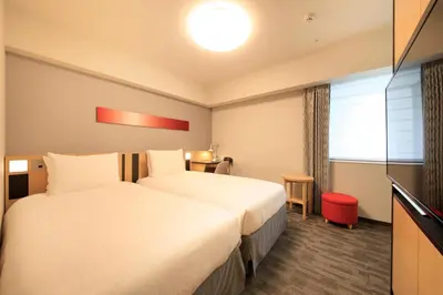 a hotel room with a large bed and a window at Richmond Hotel Tokyo Suidobashi in Tokyo