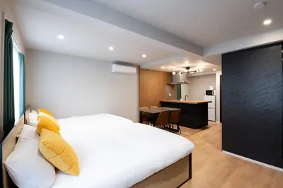 a bedroom with a white bed with yellow pillows at D-WASEDA in Tokyo