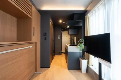 a kitchen with wooden cabinets and a hallway at D-WASEDA in Tokyo