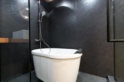 a white toilet in a bathroom with a shower at D-WASEDA in Tokyo