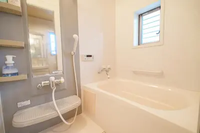a white bathroom with a tub and a window at 匯家•平和島ビル in Tokyo