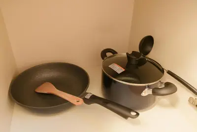 a frying pan and a pan with a spatula at 匯家•平和島ビル in Tokyo