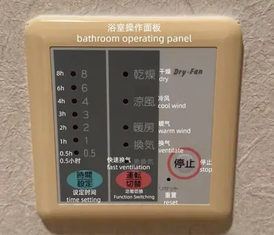 a button on a bathroom operating panel on a wall at 匯家•平和島ビル in Tokyo