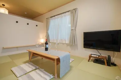 a living room with a table and a flat screen tv at 匯家•平和島ビル in Tokyo