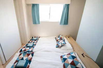 a bed in a small room with a window at Elegant Condominium Kinshicho in Tokyo