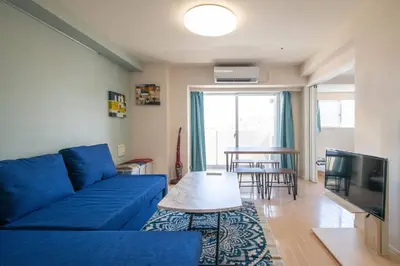 a living room with a blue couch and a table at Elegant Condominium Kinshicho in Tokyo
