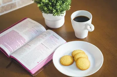 a book and two cookies on a plate and a cup of coffee at Green Sea Oshiage 5F in Tokyo