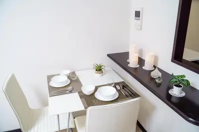 a dining room table with white dishes and candles at Green Sea Oshiage 5F in Tokyo