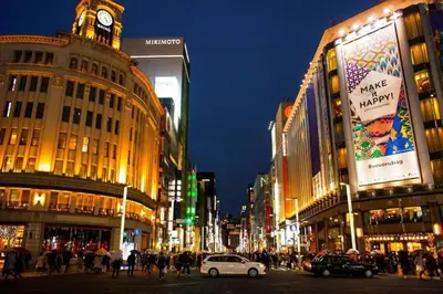 a busy city street at night with a clock tower at Green Sea Oshiage 5F in Tokyo