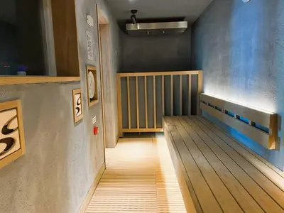 a hallway with a wooden bench in a room at Men Only Capsule Room & Sauna, Bathhouse, gim 男性専用サウナ&カプセル Minami Gakugeidai in Tokyo