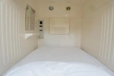 a white room with a bed and a sink at Men Only Capsule Room & Sauna, Bathhouse, gim 男性専用サウナ&カプセル Minami Gakugeidai in Tokyo