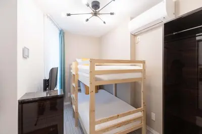 a room with two bunk beds and a desk at LaVie\u521d\u53f0 in Tokyo