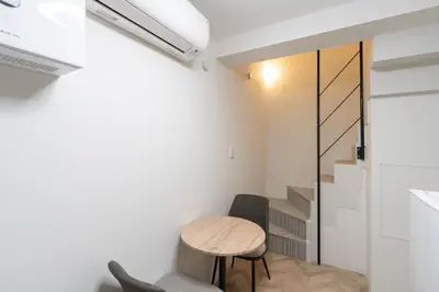 a small table and chairs in a room with white walls at LaVie\u521d\u53f0 in Tokyo