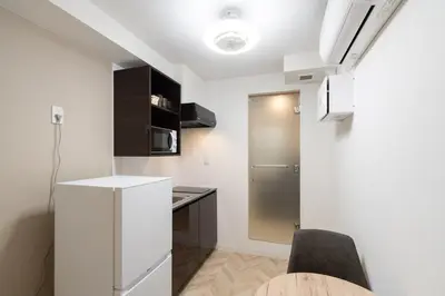 a kitchen with a white refrigerator and a table at LaVie\u521d\u53f0 in Tokyo