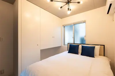 a bedroom with a large white bed with blue pillows at Luxe\u5357\u9752\u5c71 in Tokyo