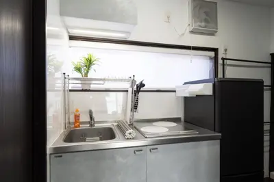 a small kitchen with a sink and a window at Apro Stay \u7530\u5712\u8abf\u5e03\u591a\u6469\u5ddd in Tokyo