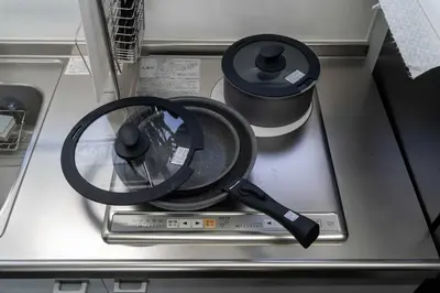 a frying pan sitting on top of a stove at Apro Stay \u7530\u5712\u8abf\u5e03\u591a\u6469\u5ddd in Tokyo