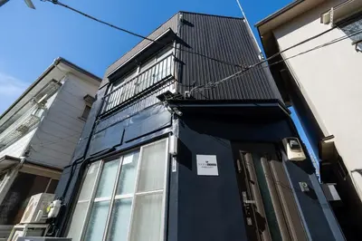 a building with a blue door on the side of it at Apro Stay \u7530\u5712\u8abf\u5e03\u591a\u6469\u5ddd in Tokyo