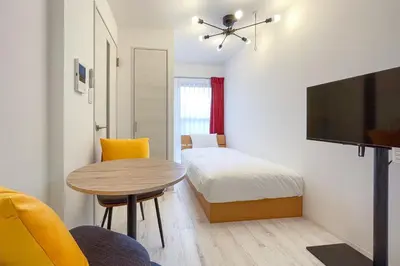 a small room with a bed and a table and a tv at \u30bf\u30b9\u30adsmart\u6771\u65b0\u5bbf in Tokyo