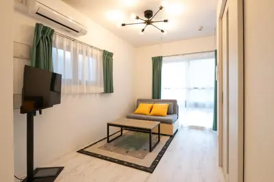 a living room with a couch and a tv at \u30bf\u30b9\u30adsmart\u6771\u65b0\u5bbf in Tokyo