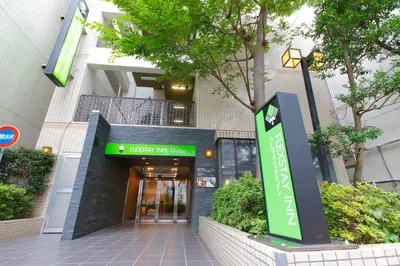 a building with a green sign in front of it at FLEXSTAY INN Ekoda in Tokyo