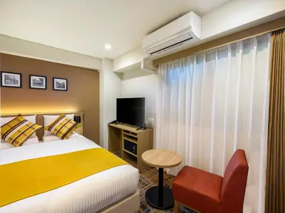 a hotel room with a bed and a television at HOTEL MYSTAYS Higashi Jujo in Tokyo