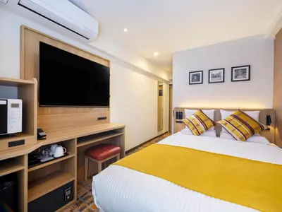 a hotel room with a bed and a flat screen tv at HOTEL MYSTAYS Higashi Jujo in Tokyo