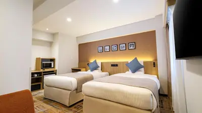 a hotel room with two beds and a tv at HOTEL MYSTAYS Higashi Jujo in Tokyo