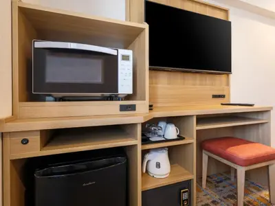 a hotel room with a tv and a microwave at HOTEL MYSTAYS Higashi Jujo in Tokyo