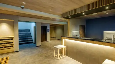 a lobby with a bar and stairs in a building at HOTEL MYSTAYS Higashi Jujo in Tokyo
