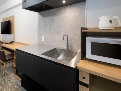 a kitchen with a sink and a microwave at HOTEL MYSTAYS Iidabashi in Tokyo