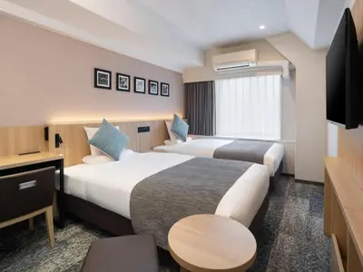 a hotel room with two beds and a television at HOTEL MYSTAYS Iidabashi in Tokyo