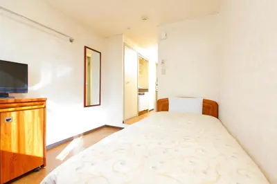 a bedroom with a bed and a flat screen tv at FLEXSTAY INN Nakanobu in Tokyo