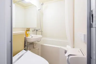 a bathroom with a sink and a toilet and a mirror at FLEXSTAY INN Nakanobu in Tokyo