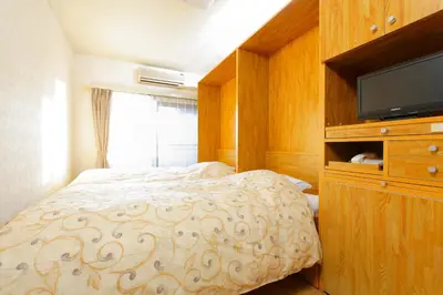 a bedroom with a bed with a dresser and a television at FLEXSTAY INN Nakanobu in Tokyo