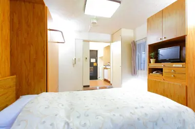 a bedroom with a bed and a flat screen tv at FLEXSTAY INN Nakanobu in Tokyo