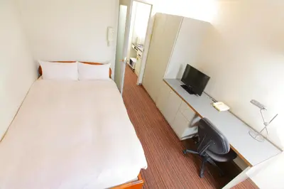 a hotel room with a bed and a desk with a computer at FLEXSTAY INN Shinurayasu in Urayasu