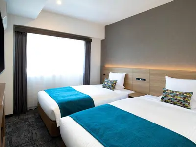 a hotel room with two beds and a window at FLEXSTAY INN Shinurayasu in Urayasu